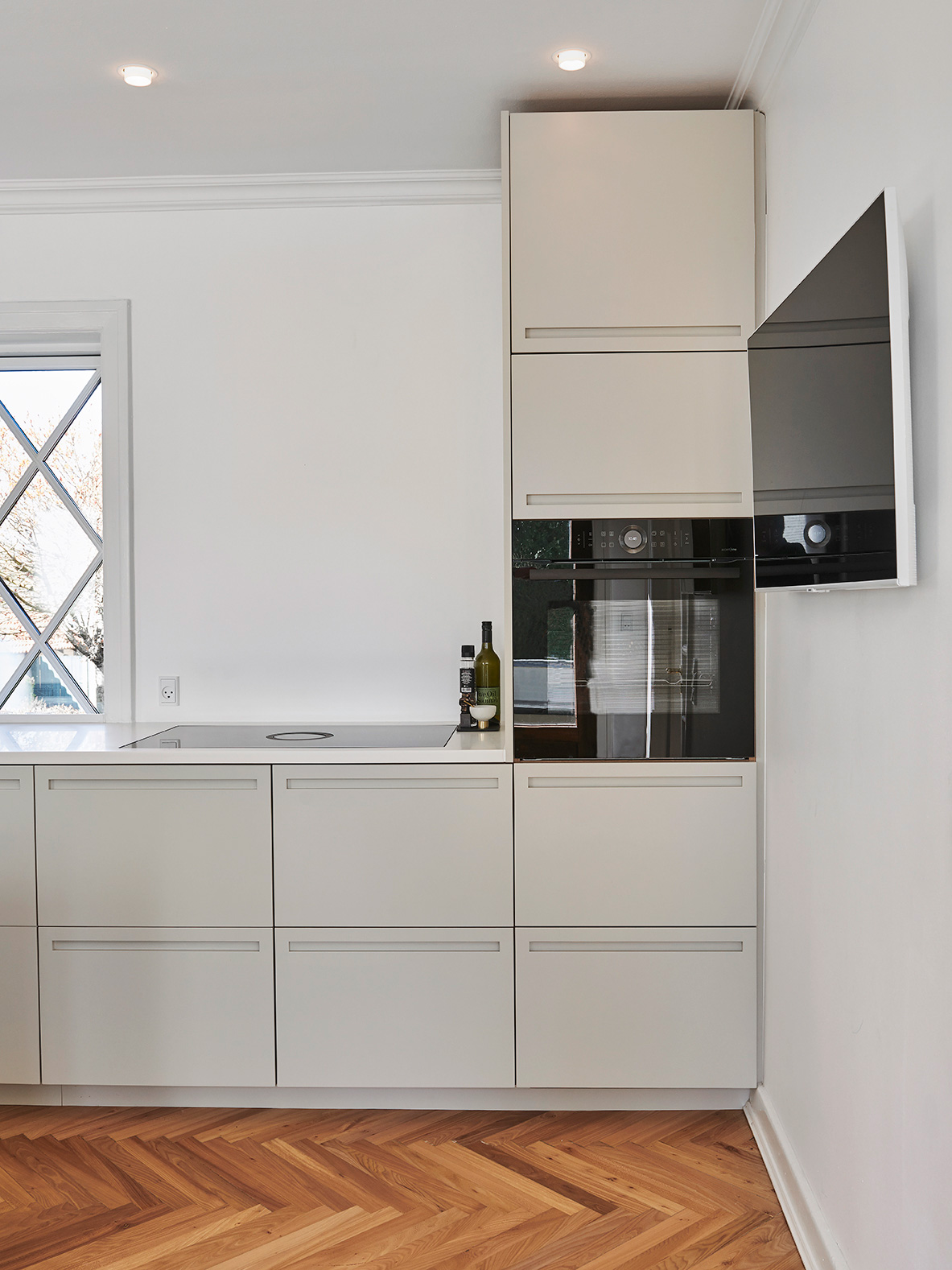 De hvidmalede elementer og bordpladerne i hvidpigmenteret ask får et fint modspil af væggens grønne nuance.